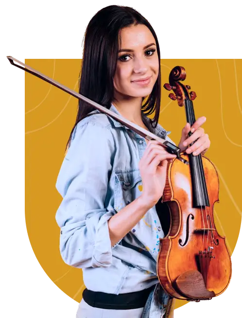 A young woman with long dark hair holds a violin and bow, smiling slightly, standing in front of a mustard yellow background. She wears a light blue denim jacket—perfectly capturing the spirit of music lessons Westchase has to offer.